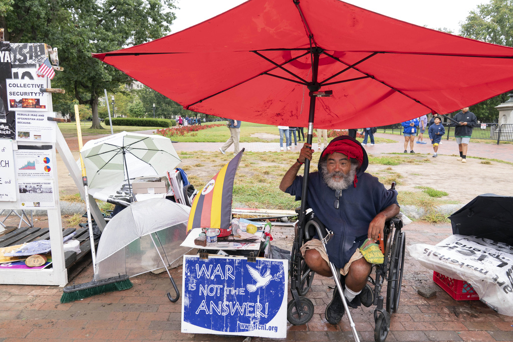 Philipos Melaku-Bello talks to people during Peace Vigil in Lafayette Park across from the White House in Washington, Sunday, Sept. 7, 2025. (AP Photo/Jose Luis Magana)