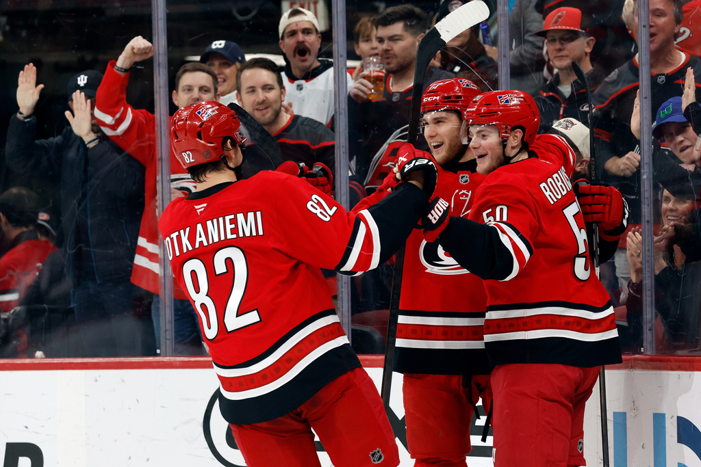 Carolina Hurricanes' Mark Jankowski, center, celebrates his goal with Carolina Hurricanes' Eric Robinson, right, and Jesperi Kotkaniemi (82) during the second period of an NHL hockey game against the Florida Panthers in Raleigh, N.C., Friday, Jan. 16, 2026. (AP Photo/Karl DeBlaker)