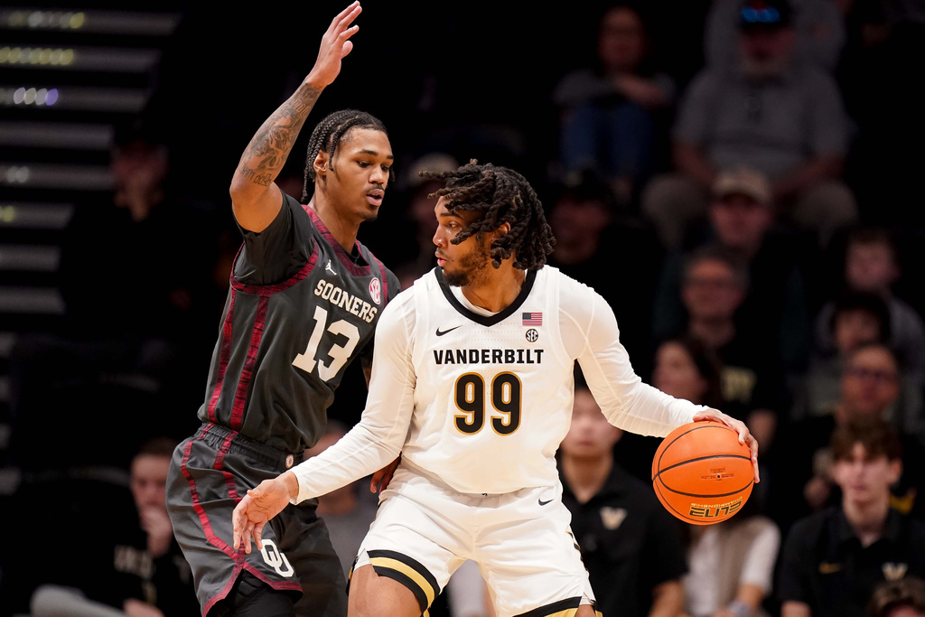 Vanderbilt forward Devin McGlockton (99) drives against Oklahoma forward Tae Davis (13) during the first half of an NCAA college basketball game Saturday, Feb. 7, 2026, in Nashville, Tenn. (AP Photo/Camden Hall)