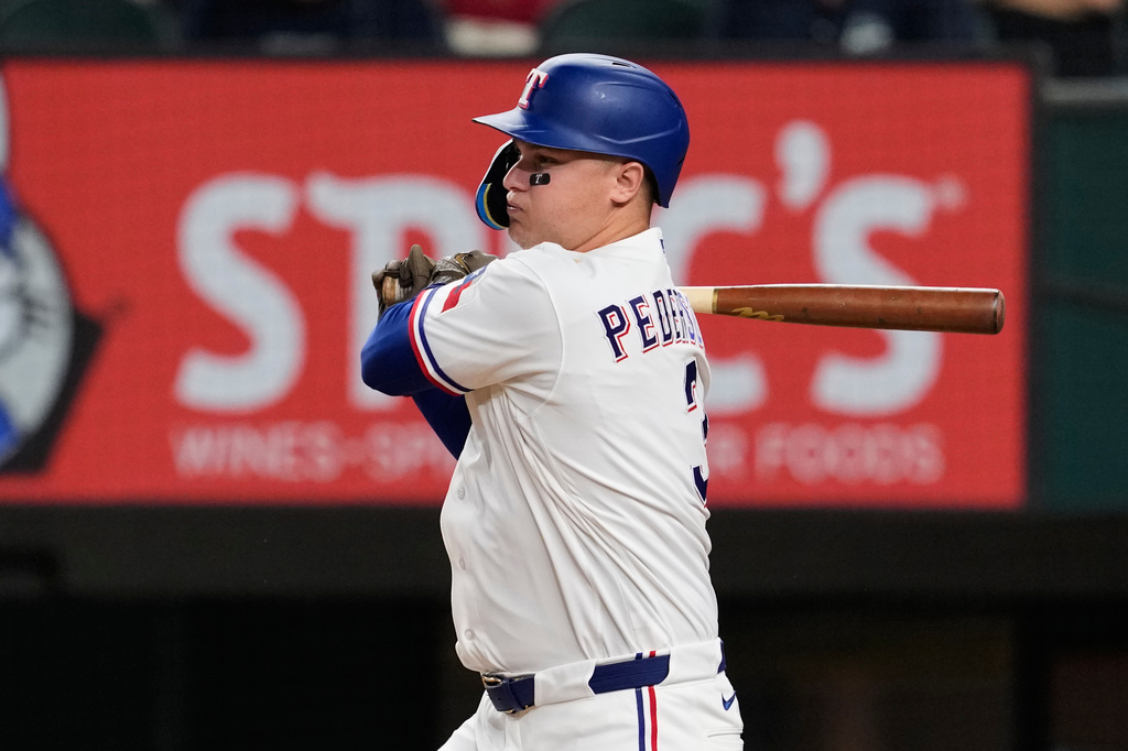 Texas Rangers' Joc Pederson follows through on a single in the eighth inning of a baseball game against the Minnesota Twins in Arlington, Texas, Monday, June 15, 2026. (AP Photo/Tony Gutierrez)