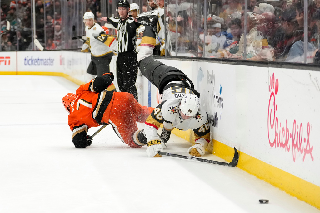 Anaheim Ducks defenseman Radko Gudas, left, falls after hip checking Vegas Golden Knights right wing Jonas Rondbjerg during the second period of an NHL hockey game Sunday, Feb. 1, 2026, in Anaheim, Calif. (AP Photo/Mark J. Terrill)