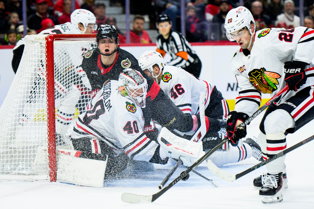Chicago Blackhawks goalie Arvid Soderblom (40) tracks the puck as Ottawa Senators' Tim Stutzle (18) crashes into the net during second-period NHL hockey game action in Ottawa, Ontario, Saturday, Dec. 20, 2025. (Spencer Colby/The Canadian Press via AP)
