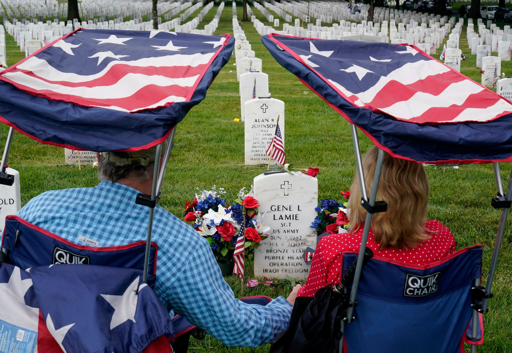 FILE - Eugene and Linda Lamie, of Homerville, Ga., sit by the grave of their son U.S. Army Sgt. Gene Lamie in Section 60 at Arlington National Cemetery on Memorial Day, Monday, May 29, 2023, in Arlington, Va. (AP Photo/Alex Brandon, file)