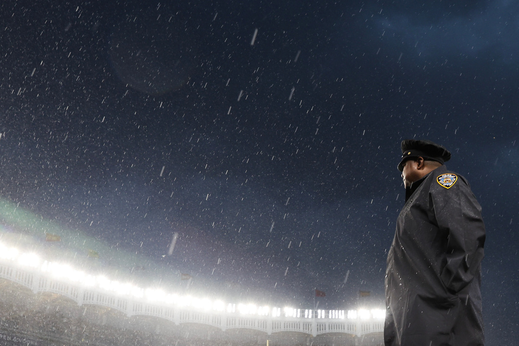 A police officer stands by as a baseball game between the New York Yankees and Boston Red Sox is delayed due to weather, Saturday, June 6, 2026, in New York. (AP Photo/Heather Khalifa)