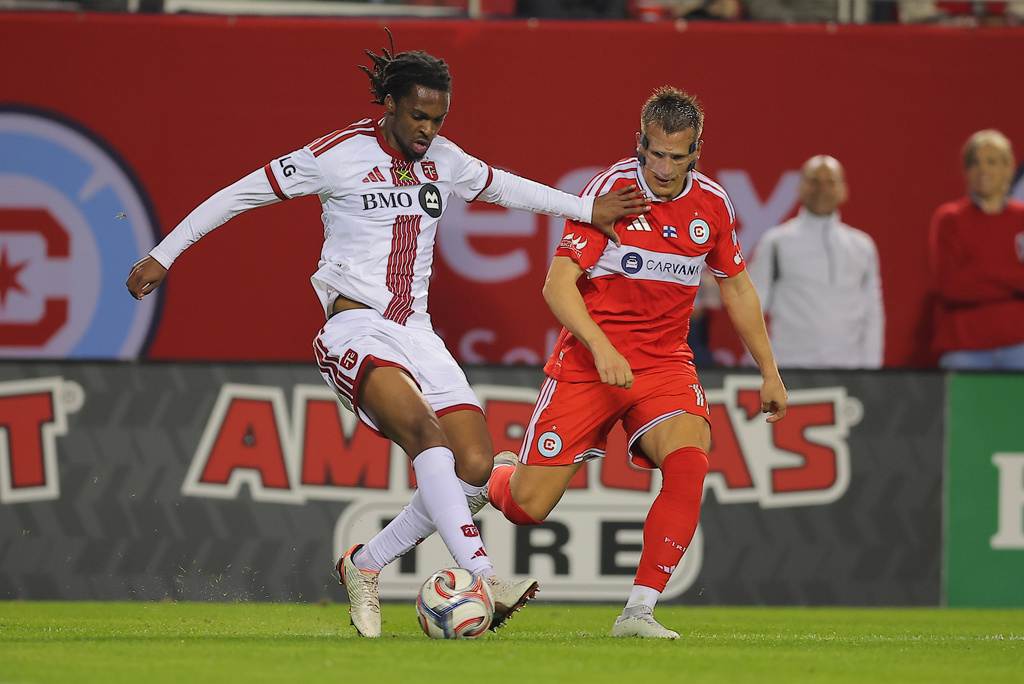 Toronto FC defender Zane Monlouis, left, controls the ball against Chicago Fire midfielder Robin Lod, right, during the second half of an MLS soccer match Saturday, May 23, 2026, in Chicago. (AP Photo/Melissa Tamez)