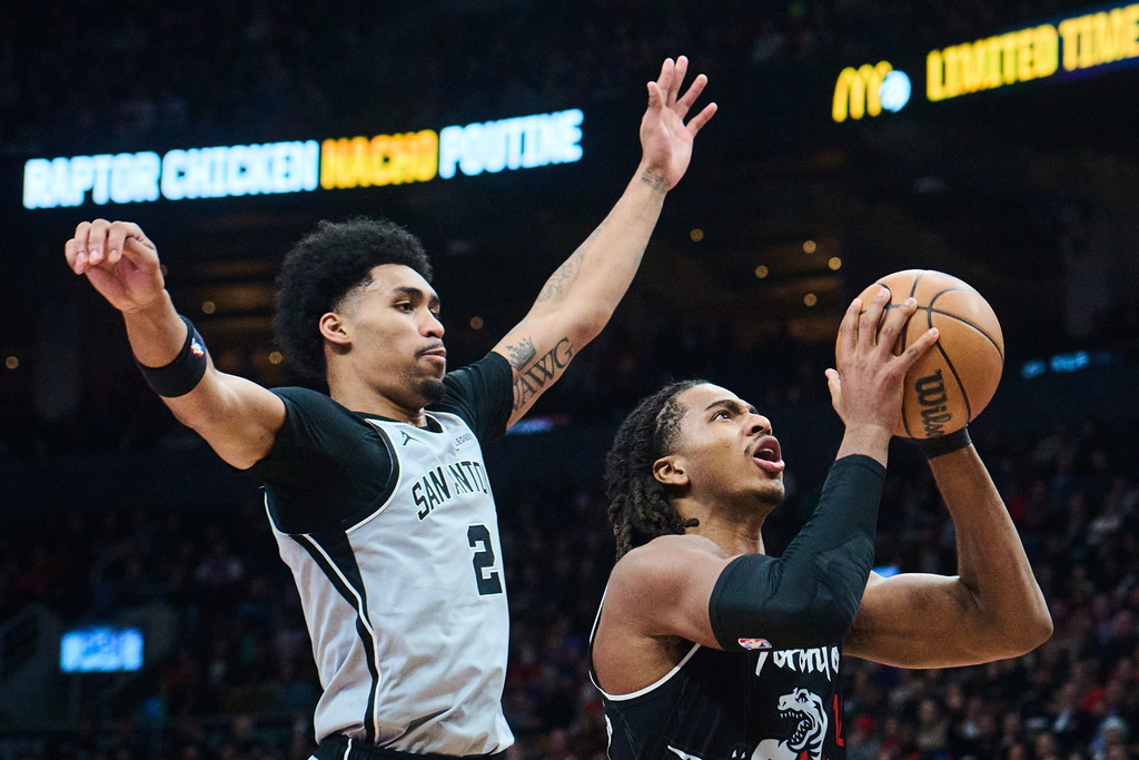 Toronto Raptors' Collin Murray-Boyles (12) drives to the net past San Antonio Spurs' Dylan Harper (2) during the first half of an NBA basketball game, in Toronto, Wednesday, Feb. 25, 2026. (Sammy Kogan/The Canadian Press via AP)
