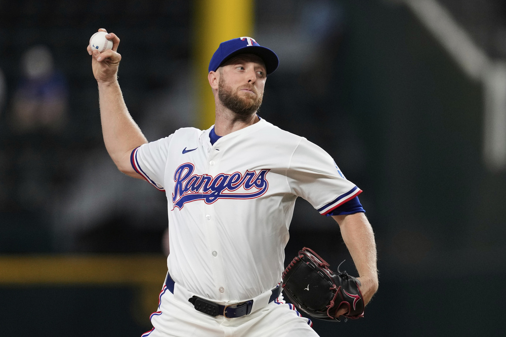 Texas Rangers starting pitcher Merrill Kelly throws to the Arizona Diamondbacks in the first inning of a baseball game Wednesday, Aug. 13, 2025, in Arlington, Texas. (AP Photo/Tony Gutierrez)