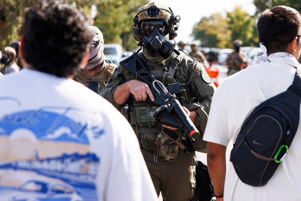 Federal officers stand guard in the Brighton Park neighborhood of Chicago, on Saturday, Oct. 4, 2025, after protesters learned that U.S. Border Patrol shot a woman Saturday morning on Chicago's Southwest Side. (Anthony Vazquez/Chicago Sun-Times via AP)