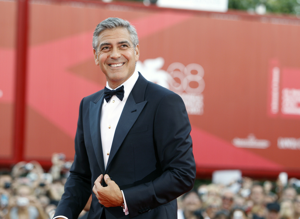 FILE - George Clooney poses on the red carpet at the premiere of his film "The Ides of March," opening the 68th edition of the Venice Film Festival in Venice, Italy on Aug. 31, 2011. (AP Photo/Andrew Medechini, File)