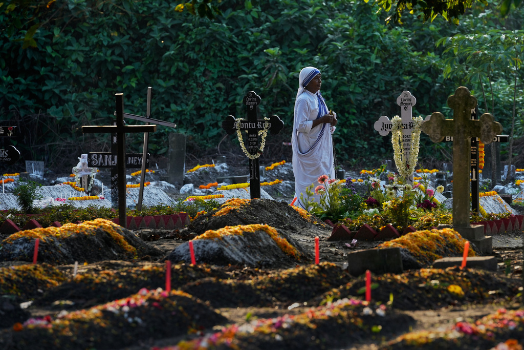 A nun of the Missionaries of Charity, the order founded by Saint Teresa, walks by the graves of their loved ones on All Souls' Day, in Kolkata, India, Sunday, Nov. 2, 2025. (AP Photo/Bikas Das)