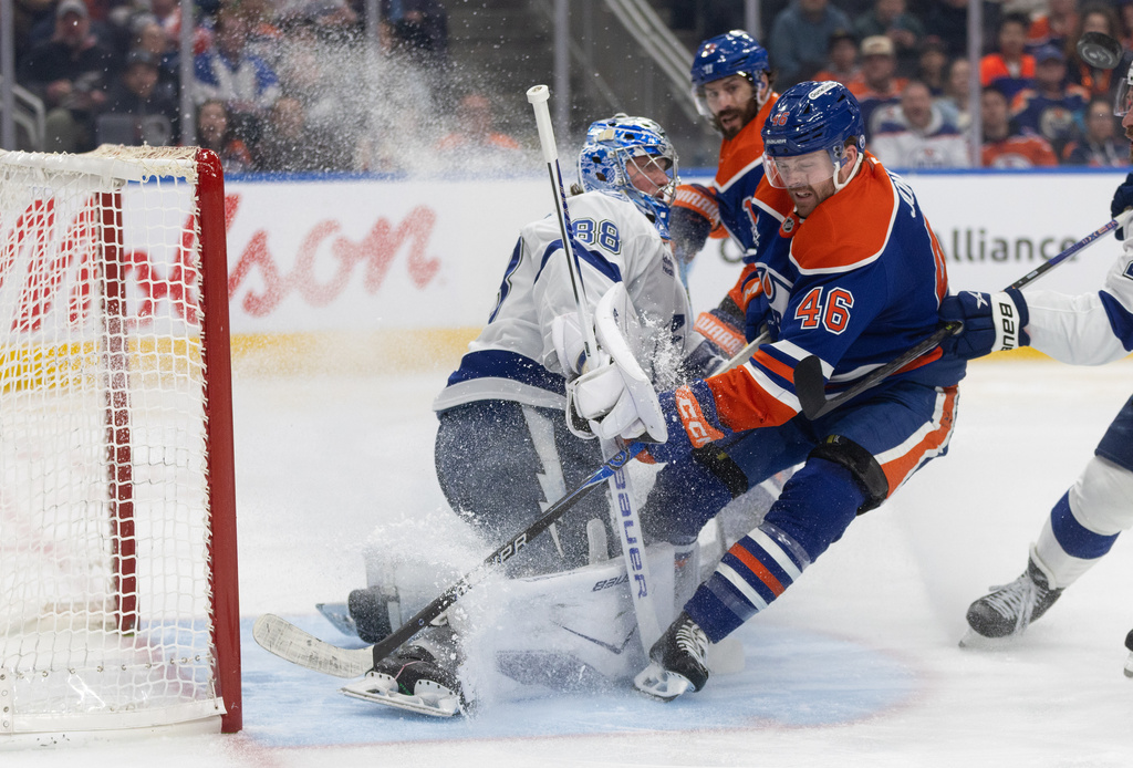 Tampa Bay Lightning goalie Andrei Vasilevskiy (88) is crashed into by Edmonton Oilers' Max Jones (46) during second period NHL action, in Edmonton on Saturday March 21, 2026. (Jason Franson/The Canadian Press via AP)