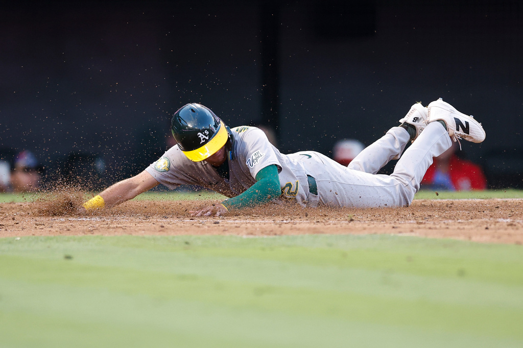 Athletics' Alika Williams (12) slides into home plate to score on a single by Henry Bolte (33) during the fifth inning of a baseball game against the Los Angeles Angels, Friday, June 26, 2026, in Anaheim, Calif. (AP Photo/Caroline Brehman)