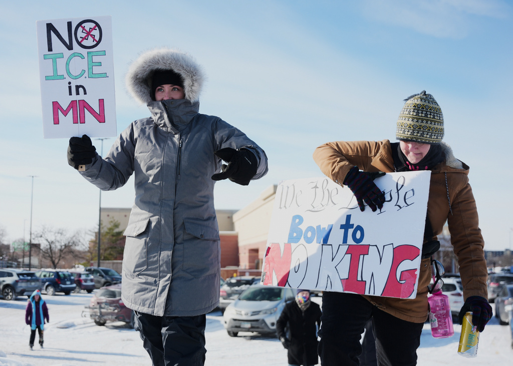 FILE - Protesters stand on the side of the road with ICE protest signs, Jan. 19, 2026, in St. Paul, Minn. (AP Photo/Angelina Katsanis, File)