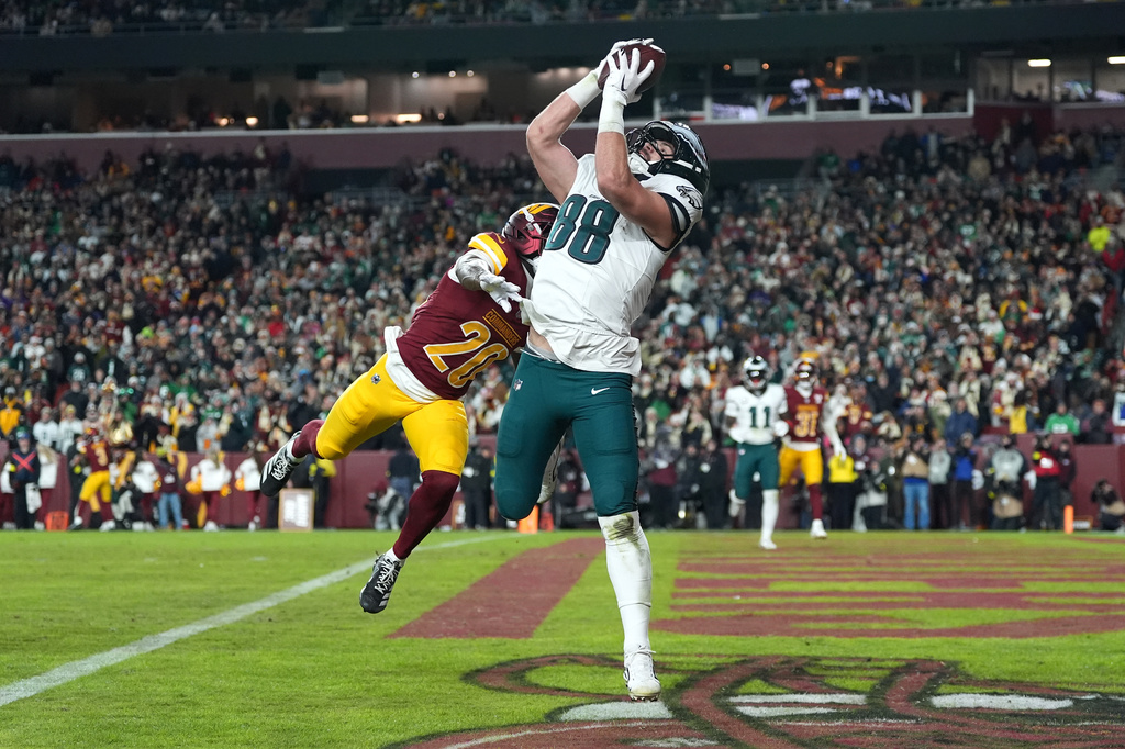 Philadelphia Eagles tight end Dallas Goedert (88) catches a pass for a touchdown against Washington Commanders safety Quan Martin (20) during the second half of an NFL football game, Saturday, Dec. 20, 2025, in Landover, Md. (AP Photo/Stephanie Scarbrough)