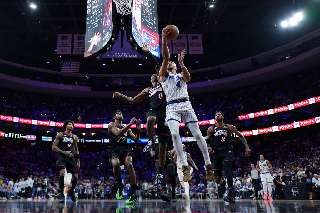 Orlando Magic's Jalen Suggs (4) goes up for a shot against Philadelphia 76ers' Tyrese Maxey (0) during the second half of an NBA play-in tournament basketball game Wednesday, April 15, 2026, in Philadelphia. (AP Photo/Matt Slocum)