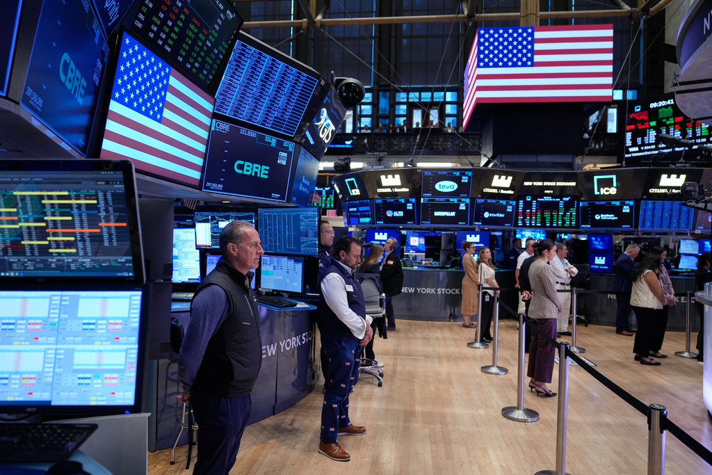 People on the floor of the New York Stock Exchange observe a moment of silence in honor of Veterans Day in New York, Tuesday, Nov. 11, 2025. (AP Photo/Seth Wenig)