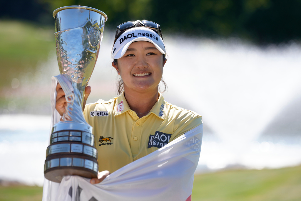 Haeran Ryu, of South Korea, celebrates with her trophy after winning the Evian Championship women's golf tournament, in Evian, eastern France, Sunday, July 12, 2026. (AP Photo/Laurent Cipriani)