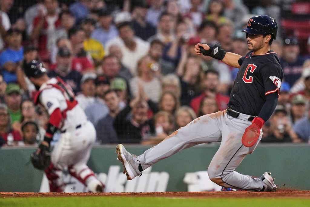 Cleveland Guardians' Steven Kwan, right, scores on a wild pitch as Boston Red Sox catcher Connor Wong chases the ball during the second inning of a baseball game at Fenway Park, Wednesday, Sept. 3, 2025, in Boston. (AP Photo/Charles Krupa)