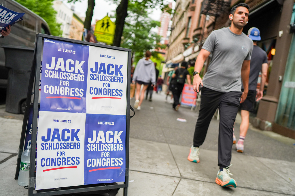 A man walks past a campaign sign for Democratic Congressional Candidate Jack Schlossberg during New York's primary election on Tuesday, June 23, 2026, in New York. (AP Photo/Ryan Murphy)