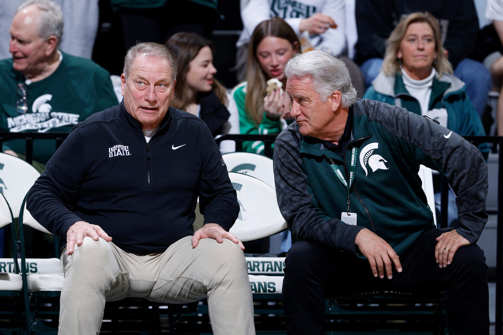 Michigan State coach Tom Izzo, left, talks with Steve Mariucci on the bench before the first half of an NCAA college basketball game, Tuesday, Feb. 17, 2026, in East Lansing, Mich. (AP Photo/Al Goldis)