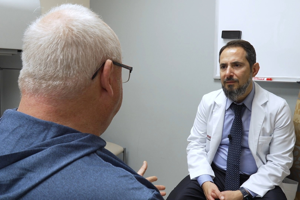 In this image made from video, Tony Hout, left, talks with Dr. Hussein Tawbi at UT MD Anderson Cancer Center in Houston, Monday, Oct. 19, 2026. (AP Photo/Lekan Oyekanmi)