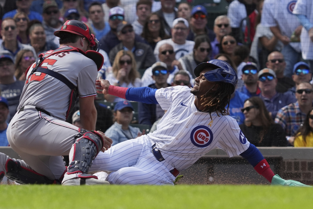 Washington Nationals catcher Riley Adams, left, tags out Chicago Cubs' Kevin Alcántara, right, at home during the fifth inning of a baseball game in Chicago, Sunday, Sept. 7, 2025. (AP Photo/Nam Y. Huh)