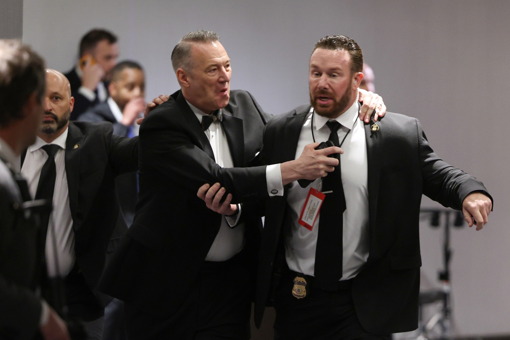 Officers assist guests to exit during the White House Correspondents Dinner, Saturday, April 25, 2026, in Washington. (AP Photo/Tom Brenner)