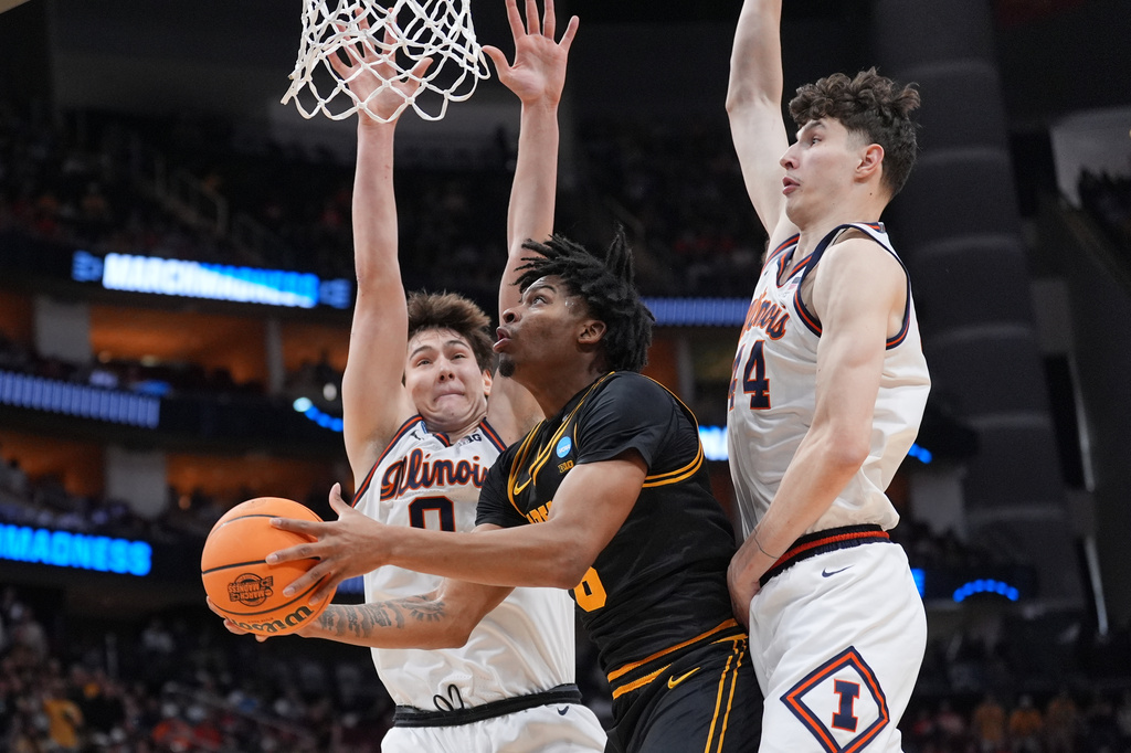 Iowa's Tavion Banks, center, goes up for a shot as Illinois' David Mirkovic (0) and Zvonimir Ivisic defend during the first half of an Elite Eight game in the NCAA college basketball tournament Saturday, March 28, 2026, in Houston. (AP Photo/Eric Gay)