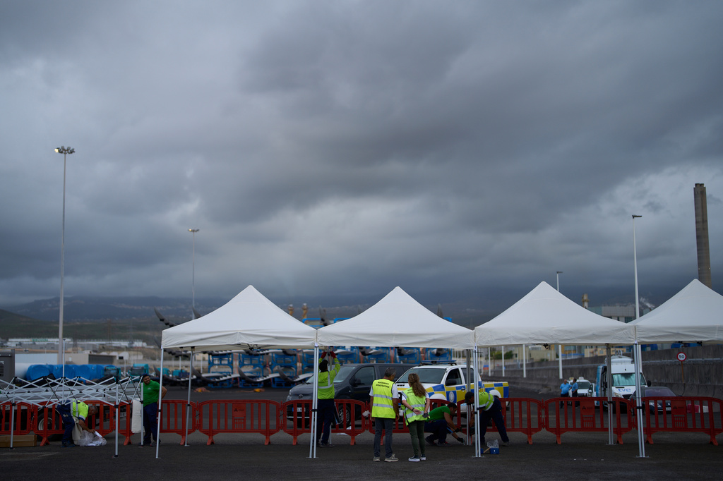 Workers set up temporary shelters in the area where passengers from the MV Hondius cruise ship are expected to arrive at the port of Granadilla in Tenerife, Canary Islands, Spain, Saturday, May 9, 2026. (AP Photo/Manu Fernandez)