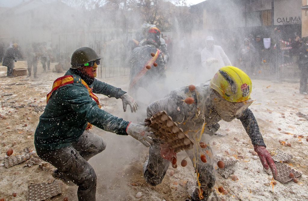 Revellers take part in the Els Enfarinats festival, a battle using flour, eggs and firecrackers, in the town of Ibi near Alicante, Spain, Sunday Dec. 28, 2025. (AP Photo/Alberto Saiz)