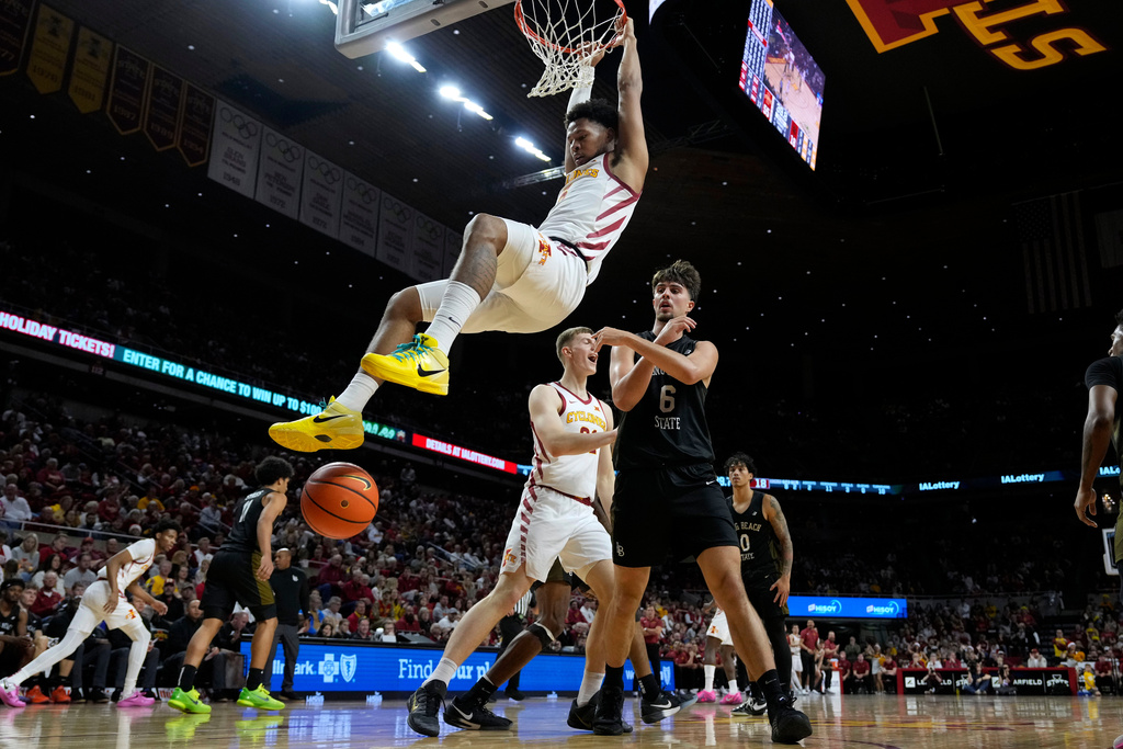 Iowa State forward Joshua Jefferson, top, hangs from the rim after dunking over Long Beach State forward Petar Majstorovic (6) during the first half of an NCAA college basketball game, Sunday, Dec. 21, 2025, in Ames, Iowa. (AP Photo/Charlie Neibergall)