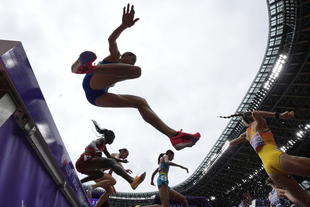 Runners compete in a heat of a women's 400 meters hurdles at the World Athletics Championships in Tokyo, Monday, Sept. 15, 2025. (AP Photo/Ashley Landis)