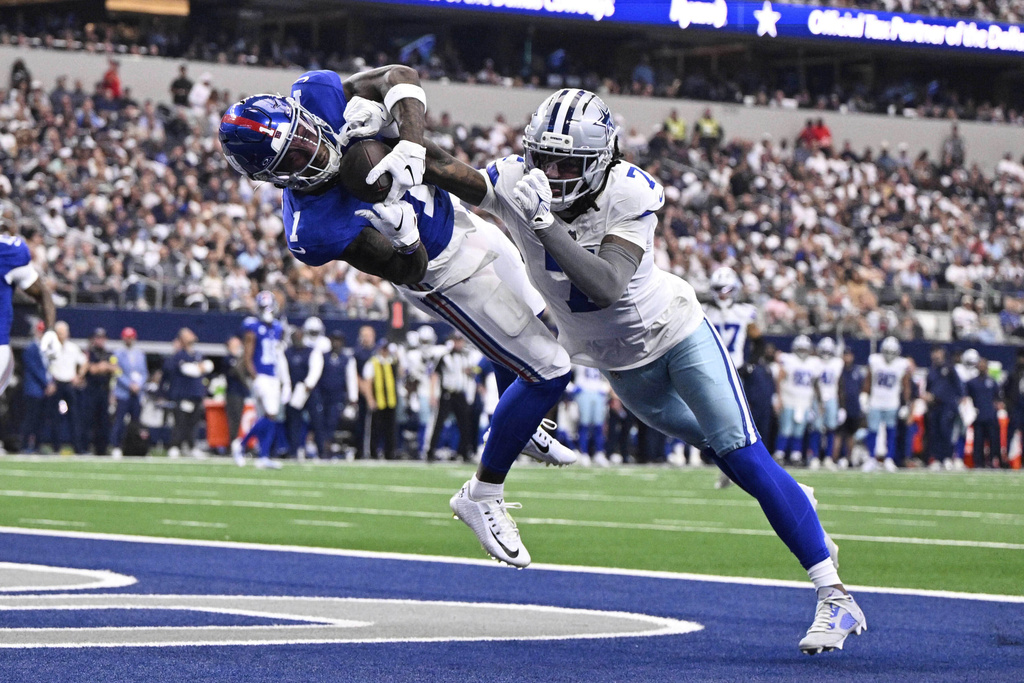 New York Giants wide receiver Malik Nabers catches a touchdown pass as Dallas Cowboys cornerback Trevon Diggs (7) defends in the first half of an NFL football game Sunday, Sept. 14, 2025, in Arlington, Texas. (AP Photo/Jerome Miron)