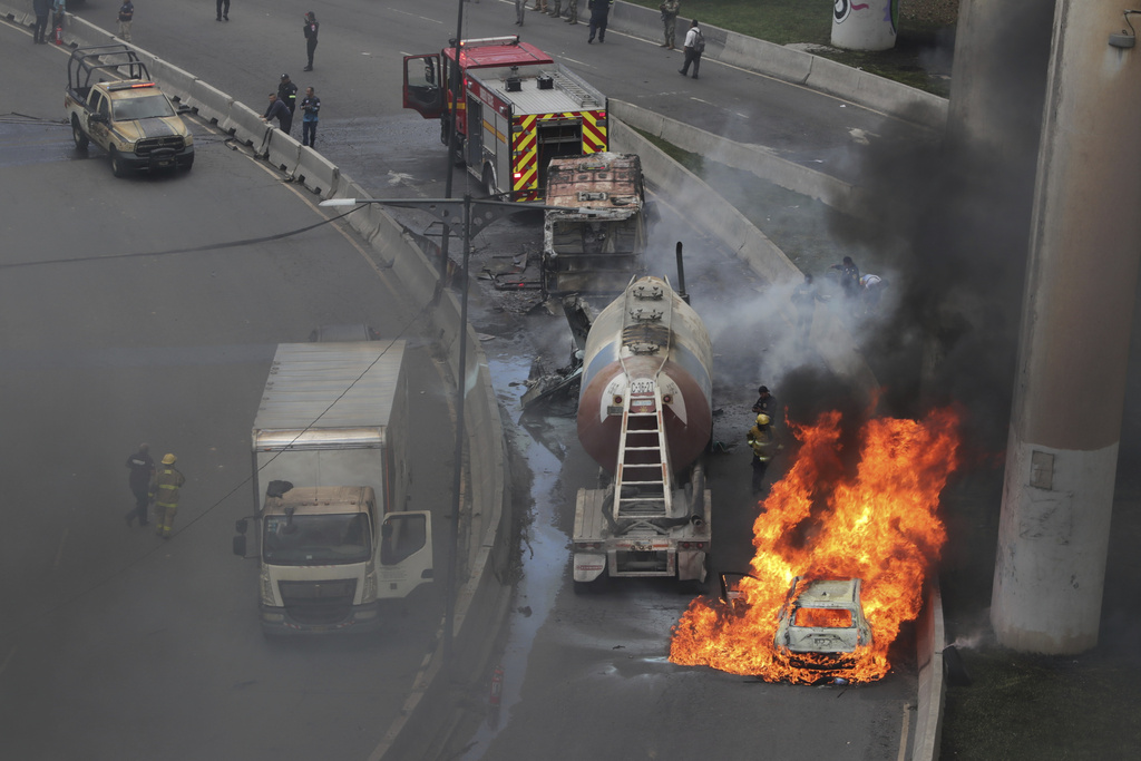 A vehicle burns near the site of a gas tanker explosion under a highway overpass in Mexico City, Wednesday, Sept. 10, 2025. (AP Photo/Tristan Velazquez)