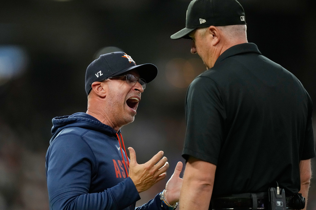 Houston Astros manager Joe Espada, left, argues with first base umpire Lance Barrett (16) during the third inning of a baseball game against the Los Angeles Angels Wednesday, Aug. 19, 2026, in Houston. (AP Photo/David J. Phillip)