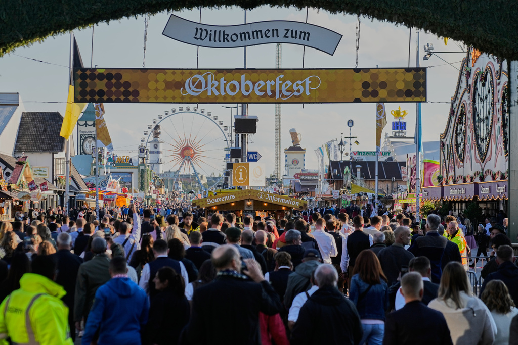 Visitors walk to the re-opening of the Oktoberfest that was closed since the morning after a bomb threatening in Munich, Germany, Wednesday, Oct.1, 2025. (AP Photo/Matthias Schrader)