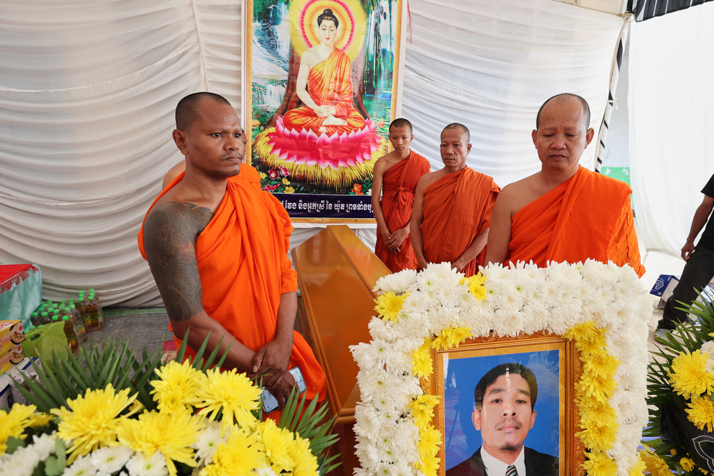 In this photo released by Agence Kampuchea Press (AKP), Cambodian Buddhist monks surround a coffin with the body of Dy Nay, killed during a clash with Thai soldiers in Prey Chan village, Banteay Meanchey province, on the border with Thailand, at Prey Chan village, Banteay Meanchey province, Cambodia, Thursday, Nov. 13, 2025 (AKP via AP)