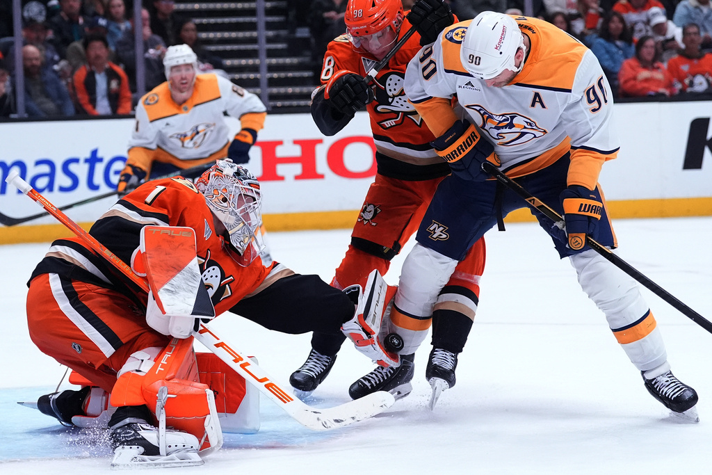 Anaheim Ducks' goaltender Lukas Dostal reaches of the puck against Nashville Predators' center Ryan O'Reilly (90) during the second period of an NHL hockey game Tuesday, April 7, 2026, in Anaheim, Calif.. (AP Photo/Scott Strazzante)
