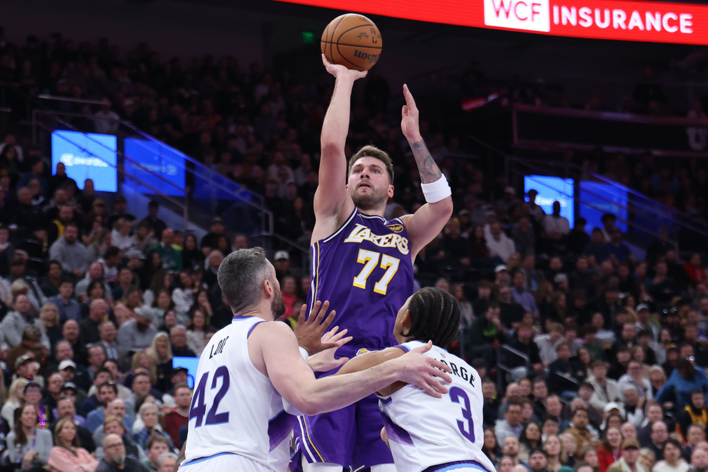 Los Angeles Lakers guard Luka Doncic (77) shoots over Utah Jazz forward Kevin Love (42) and guard Keyonte George (3) during the second half of an NBA basketball game, Thursday, Dec. 18, 2025, in Salt Lake City. (AP Photo/Rob Gray)