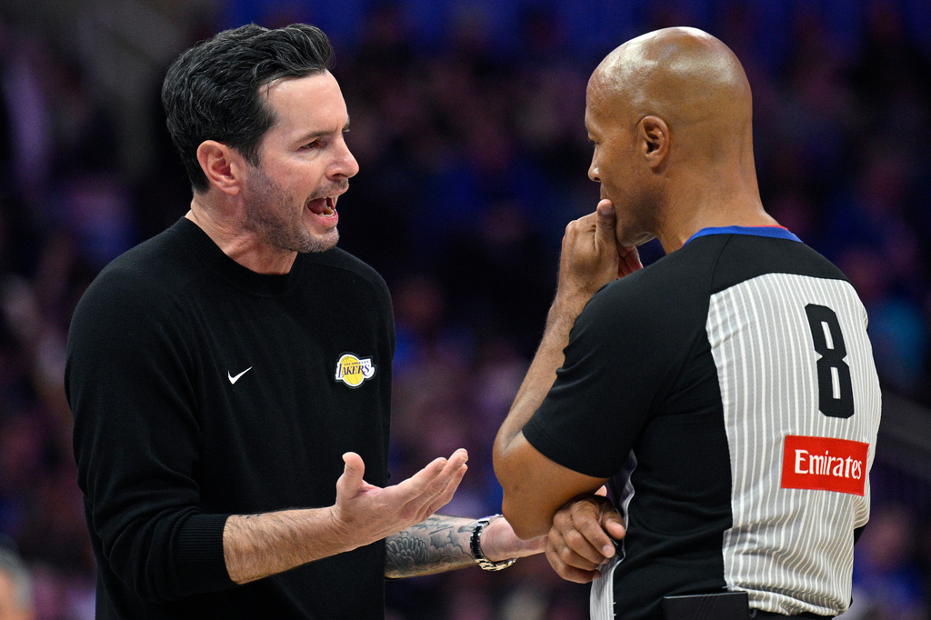 Los Angeles Lakers head coach JJ Redick, left, argues a call with official Marc Davis (8) during the first half of an NBA basketball game against the Orlando Magic, Saturday, March 21, 2026, in Orlando, Fla. (AP Photo/Phelan M. Ebenhack)