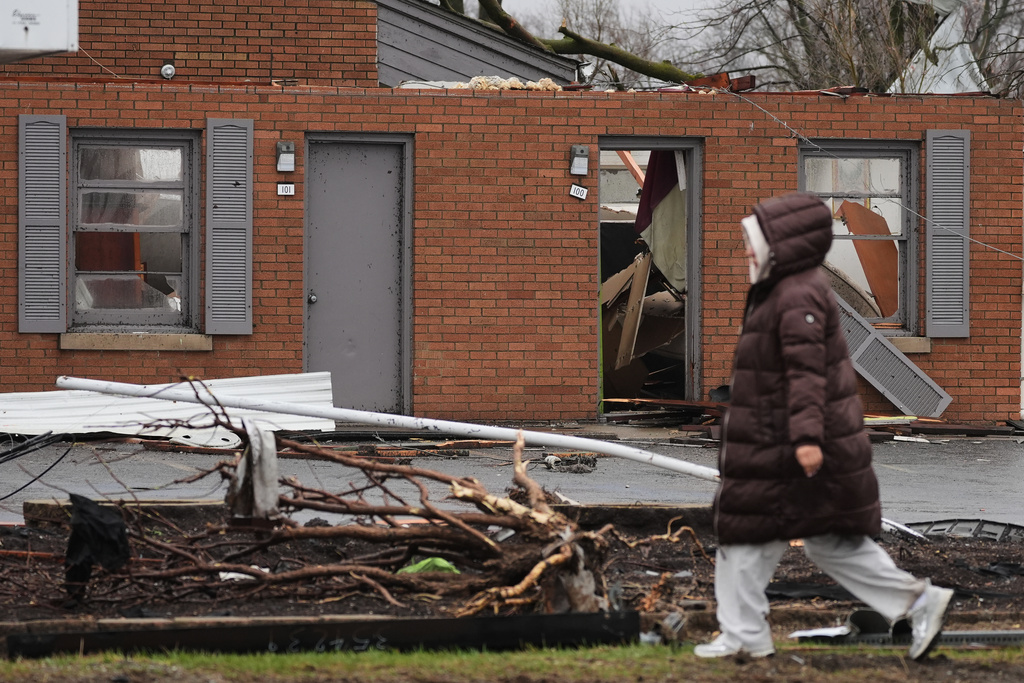 A person walks by the damage in the aftermath of a powerful storm that ripped through the area a day earlier in Kankakee, Ill., Wednesday, March 11, 2026. (AP Photo/Nam Y. Huh)