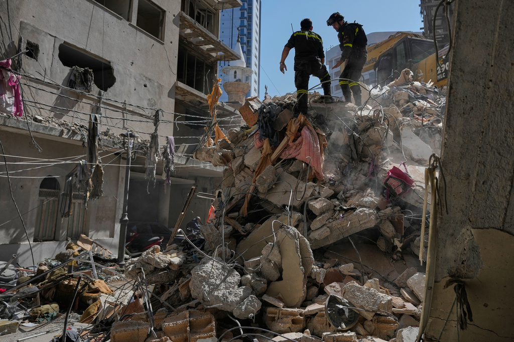 Lebanese civil defense workers inspect the rubble at the site of a building destroyed in an Israeli airstrike a day earlier in Beirut, Lebanon, Thursday, April 9, 2026. (AP Photo/Hussein Malla)
