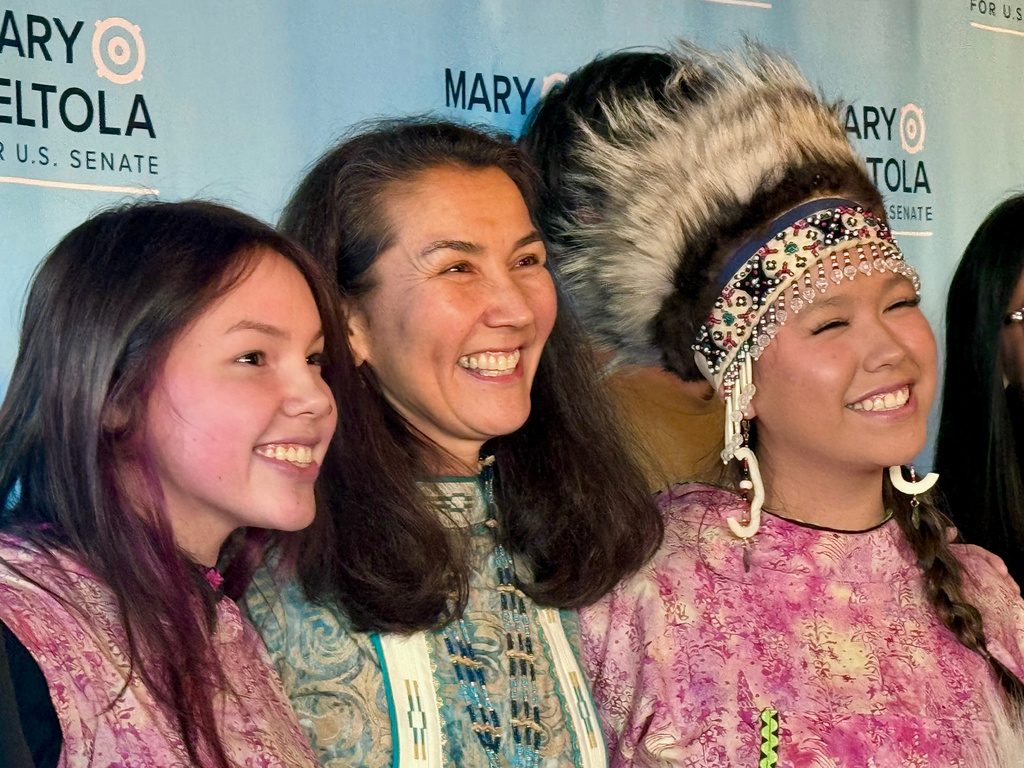 In this photo made with a smartphone, Democratic U.S. Senate candidate Mary Peltola, center, stands with supporters during a campaign event in Anchorage, Alaska, on Wednesday, Oct. 21, 2026. (AP Photo/Haven Daley)
