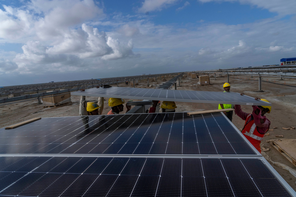 FILE - Workers install solar panels at the under-construction Adani Green Energy Limited's Renewable Energy Park in the salt desert of Karim Shahi village, near Khavda, Bhuj district near the India-Pakistan border in the western state of Gujarat, India, Sept. 21, 2023. (AP Photo/Rafiq Maqbool, File)