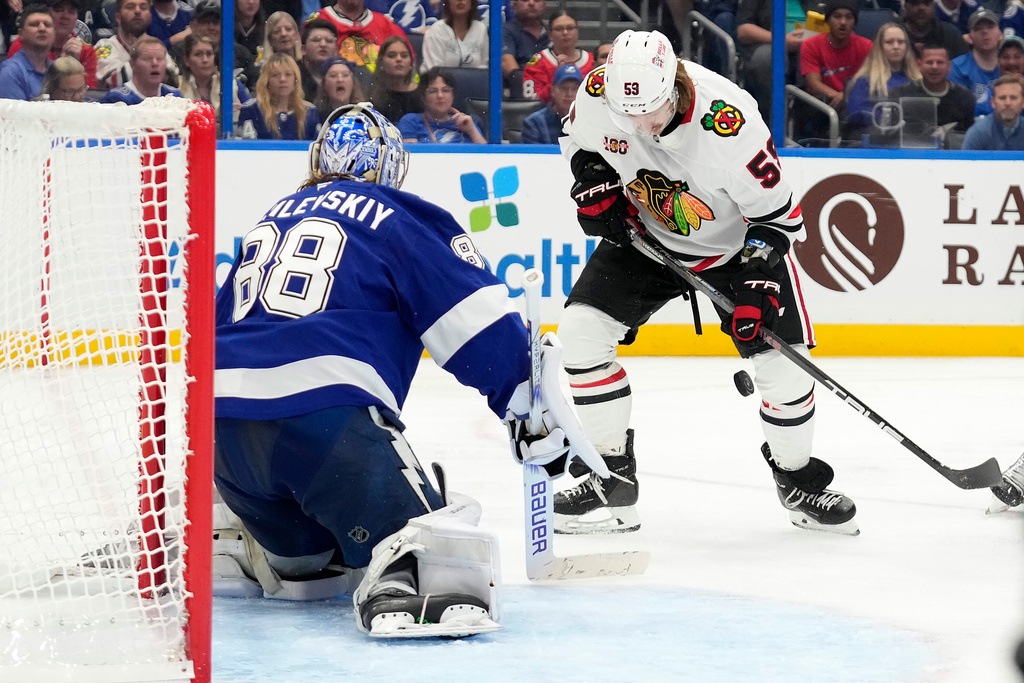 Chicago Blackhawks left wing Tyler Bertuzzi (59) plays a bouncing puck in front of Tampa Bay Lightning goaltender Andrei Vasilevskiy (88) during the third period of an NHL hockey game Thursday, Oct. 23, 2025, in Tampa, Fla. (AP Photo/Chris O'Meara)