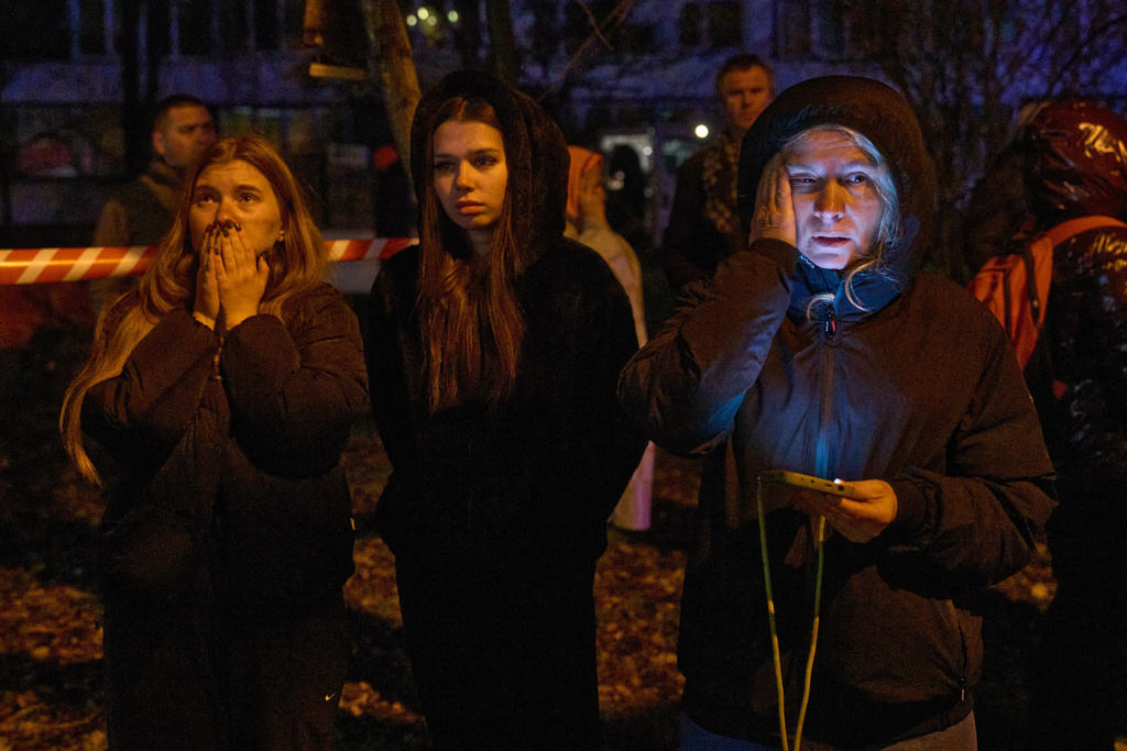 Residents watch their homes burn after a Russian drone hit a multistory residential building in Kyiv, Ukraine, Tuesday, Nov. 25, 2025. (AP Photo/Efrem Lukatsky)