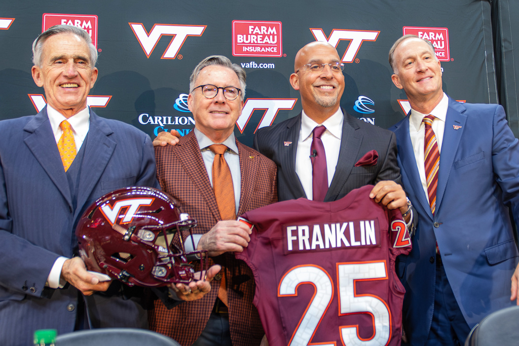 James Franklin, second from right, Virginia Tech's new head football coach, holds up a No. 25 jersey with, from left, Virginia Tech Board of Visitors member John Rocovich, Virginia Tech President Timothy Sands and Athletic Director Whit Babcock, after Franklin was introduced during an NCAA college football news conference, Wednesday, Nov. 19, 2025, in Blacksburg, Va. (AP Photo/Robert Simmons)