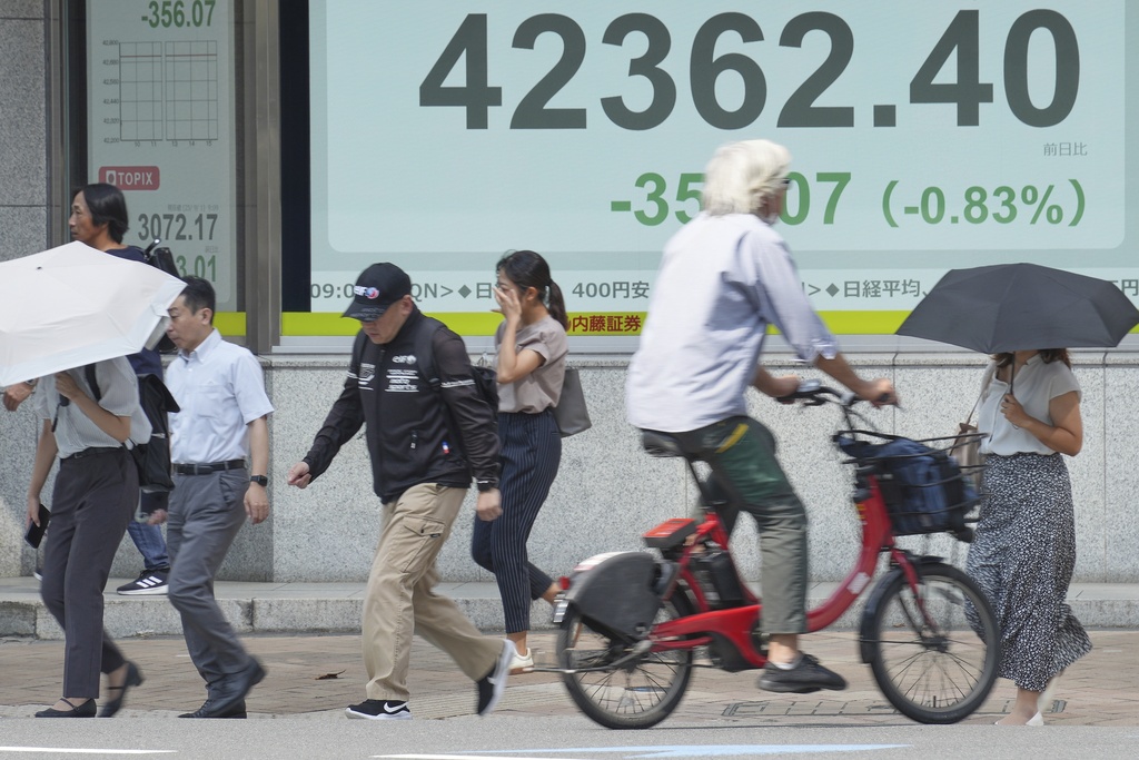 People walk in front of an electronic stock board showing Japan's Nikkei index at a securities firm Monday, Sept. 1, 2025, in Tokyo. (AP Photo/Eugene Hoshiko)