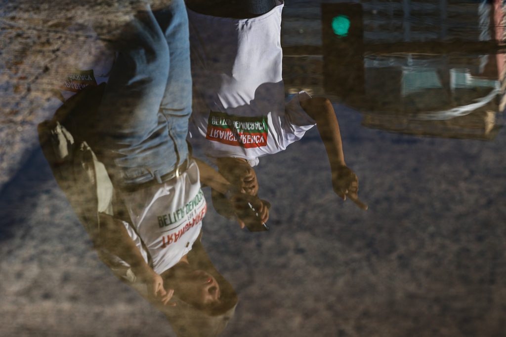 Members of the religious sect Iglesia Ni Cristo (Church of Christ) are reflected on a puddle of water as they participate in a three-day anti-corruption rally at Manila's Rizal Park, Philippines, Sunday, Nov. 16, 2025. (AP Photo/Mark Cristino)