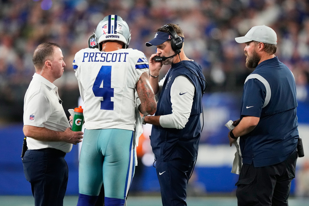 Dallas Cowboys quarterback Dak Prescott (4) talks to head coach Brian Schottenheimer during the first half of an NFL football game against the New York Giants, Sunday, Sept. 13, 2026, in East Rutherford, N.J. (AP Photo/Yuki Iwamura)
